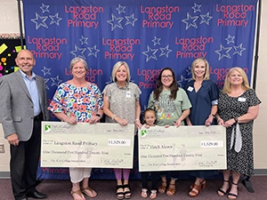 Winners holding checks